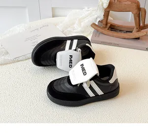 Gros plan de baskets noir et blanc pour filles avec velcro sur un fond en tissu tissé