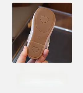 Detailed view of non-slip rubber sole with heart patterns on pink girls' leather shoes