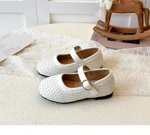 Detailaufnahme von weißen Mädchen-Mary-Janes mit Strasssteinen und Steppmuster-Textur