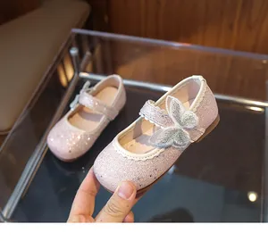 Close-up of glittery pink girls Mary Jane shoes featuring embroidered butterfly detail