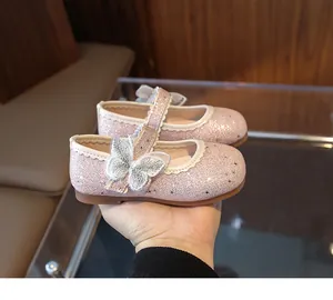 Close-up of pink sequin Mary Jane shoes with mesh embroidered butterfly and wavy trim