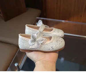Detailed close-up of girls' silver sequin Mary Jane shoes with lace butterfly and stars