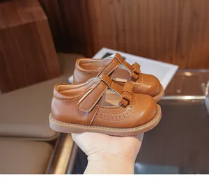 Détail de chaussures Mary Jane en cuir marron avec perforations brogue et nœuds
