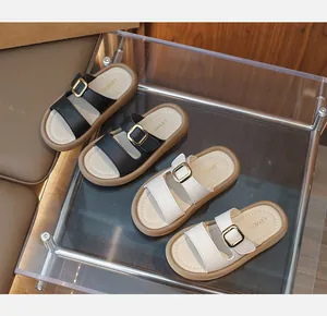 Detail of girls' two-strap sandals with golden metal buckles and textured faux leather finish