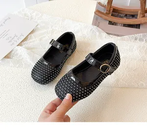 Detailansicht der schwarzen Mary Jane Schuhe mit Strasssteinen und Goldschnalle für Mädchen