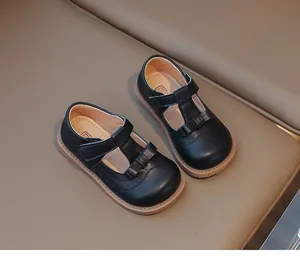Détail de chaussures Mary Jane noires vernies pour filles avec bride en T et nœud
