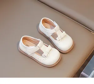 Détail de chaussures Mary Jane blanches avec nœud et motifs de dentelle découpés