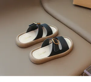Close-up of stylish girls sandals with black leather straps and golden buckles