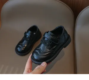 Close-up of black brogue girls' shoes with velcro strap and non-slip rubber soles