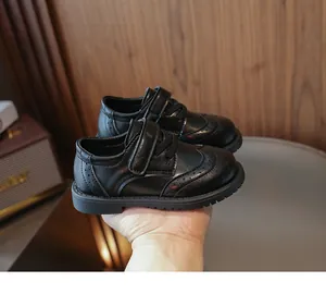 Close-up of girls black leather shoes with vintage brogue details and non-slip rubber sole