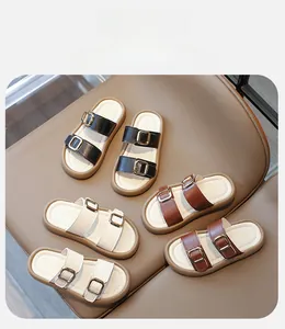 Gros plan de sandales pour enfants à double boucle en noir, marron et couleur crème
