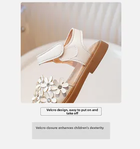 Détail de sandale blanche pour fille avec bride velcro, fleur et strass brillant