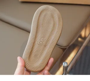 Close-up of non-slip wave texture and size label on the bottom of girls' summer slippers