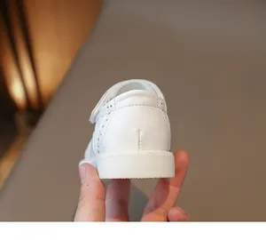 Close-up of white girls leather school shoes showing heel stitching and hollow-out detail