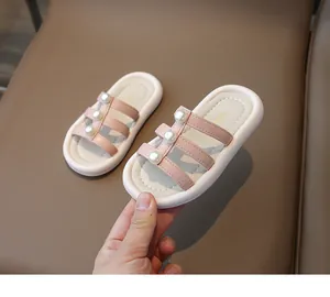 Dettaglio di sandali rosa per bambina con perle e suole bianche flessibili