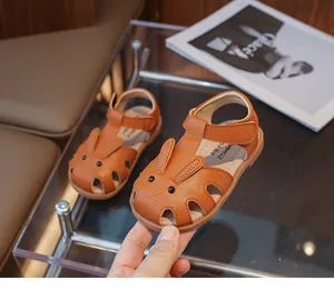Gros plan de sandales marron pour filles avec motif lapin et bride velcro réglable