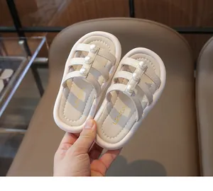 Dettaglio di sandali crema per bambina con eleganti perle e cinturini in morbida pelle