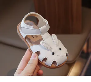 Détail de sandales blanches pour bébé avec oreilles de lapin et fermeture velcro