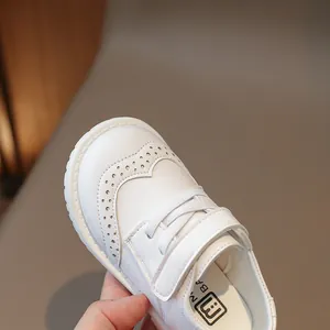 Girls white faux leather shoes with classic brocade carving and hook and loop closure
