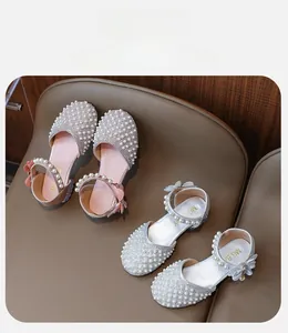 Details von rosa und silbernen Prinzessinnenschuhen mit Perlen und Tüllblumen