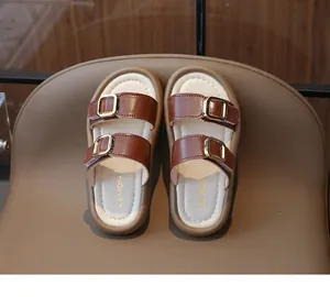 Vue de dessus de mules en cuir marron pour filles avec boucles dorées et semelle souple