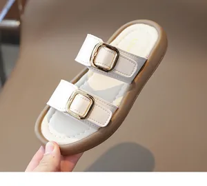 Détail de sandales beiges pour filles avec doubles boucles dorées et semelle épaisse