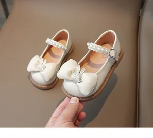 Détail de chaussure Mary Jane crème avec nœud, lapin en strass et bride de perles