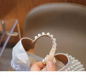 Details von Glitzersandalen mit weißem Perlenbesatz und verstellbarem Klettverschluss
