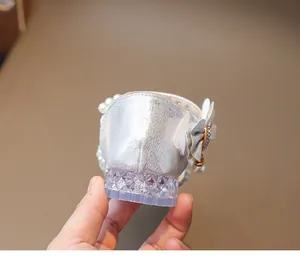 Details von silbernen Mädchen-Prinzessin-Schuhen mit Perlen und Kristallabsatz