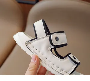Gros plan sur la sandale enfant à velcro montrant le cuir beige et les coutures fines