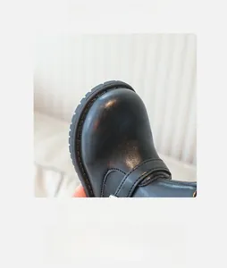 Gros plan sur le bout rond et la texture du cuir brillant de ces bottines filles
