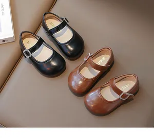 Detalle de zapatos Mary Jane brillantes para niñas con hebillas de strass en negro y marrón