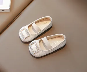 Detalle de manoletinas de tweed blanco para niñas con hebilla de perlas y suela suave