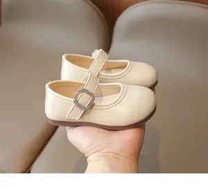 Detalle de zapato Mary Jane beige con hebilla de strass y textura de cuero sintético suave