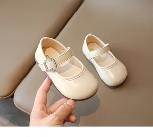 Detalle de zapatos Mary Jane crema para niña con tira de strass y acabado brillante