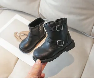 Détail de bottines noires pour filles avec doubles boucles argentées et fermeture éclair