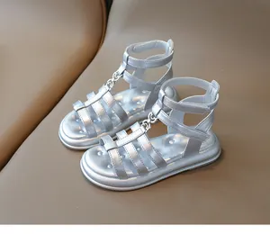 Détail des sandales spartiates argentées avec brides métalliques et fermeture velcro