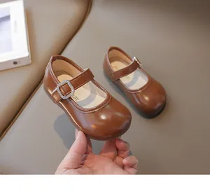Detalle de zapatos para niñas en charol color caramelo con hebilla de strass brillante