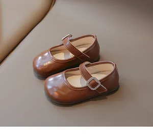 Detalle de zapatos Mary Jane marrones para niñas con hebilla cuadrada de pedrería brillante