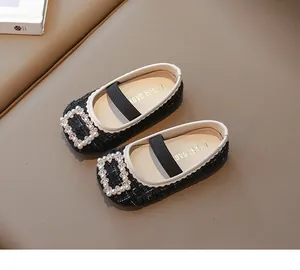 Detalle de zapatos Mary Jane de tweed negro con hebilla de perlas y brillantes strass