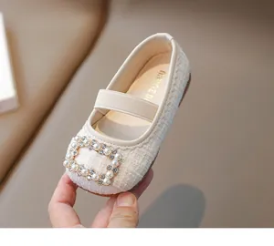 Detalle de manoletinas Mary Jane de tweed para niña con hebilla de perlas y strass