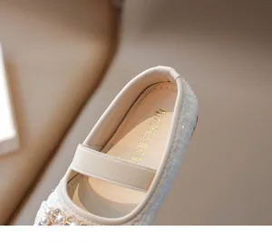 Detalle de zapatos Mary Jane para niña en tweed crema con hebilla de perlas y strass