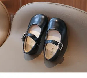 Detalle de zapatos Mary Jane negros de charol para niña con hebilla de strass brillante
