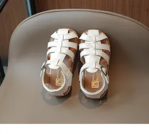 Detail of white woven summer sandals for girls with metal buckle and soft brown rubber sole