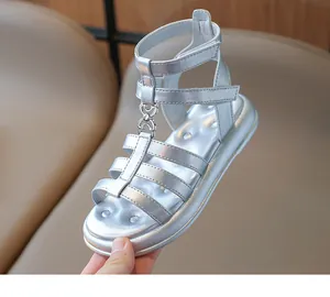Détail de sandales gladiateur argentées pour filles avec chaînes et bride velcro