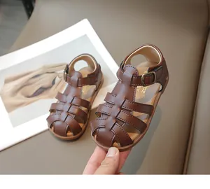 Detailed view of dark brown woven leather sandals with vintage buckle for kids