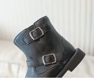 Détail de bottines noires pour filles avec boucles métalliques et coutures texturées