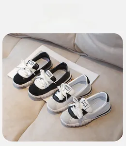 Detail of children's black and white sneakers with bow decor and thick anti-slip soles