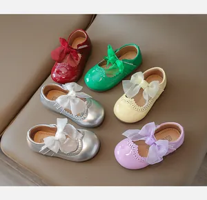Close-up of colorful girls' Mary Jane shoes featuring large silk bows and brogue details