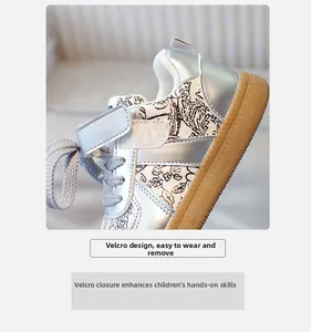Detail of kids athletic sneaker featuring silver metallic finish and easy Velcro strap